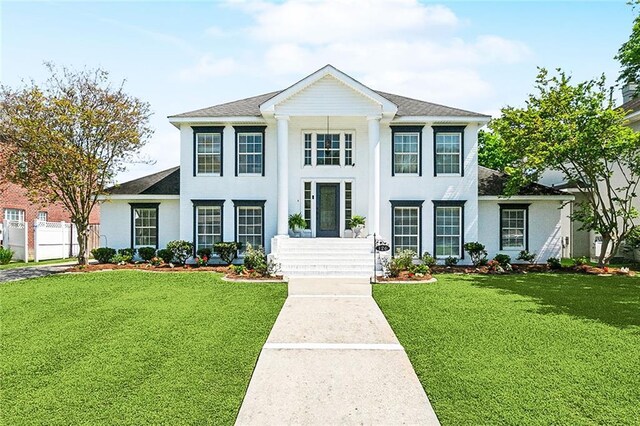 126 Woodchase Dr, Belle Chasse, LA 70037 - neoclassical home with roof with shingles, fence, stucco siding, and a front yard