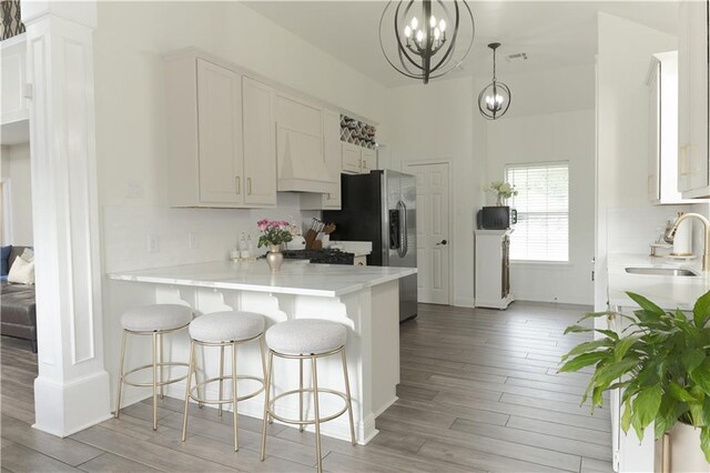 126 Woodchase Dr, Belle Chasse, LA 70037 - kitchen featuring a sink, a notable chandelier, light countertops, and light wood-style floors