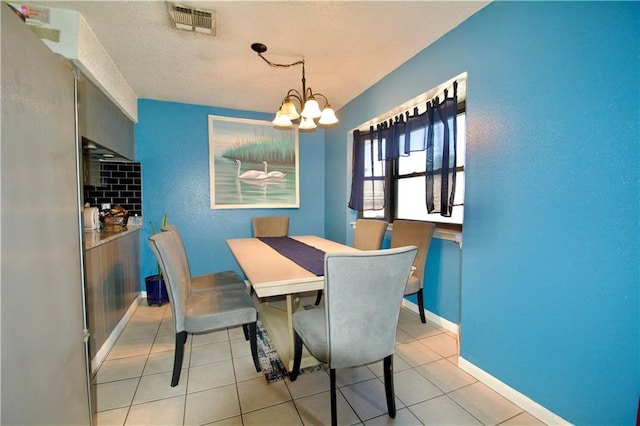 3209 Jennifer Ct, Marrero, LA 70072 - dining area with a chandelier, light tile patterned floors, baseboards, and a textured ceiling