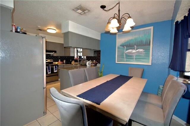 3209 Jennifer Ct, Marrero, LA 70072 - dining space featuring a chandelier, light tile patterned floors, and a textured ceiling
