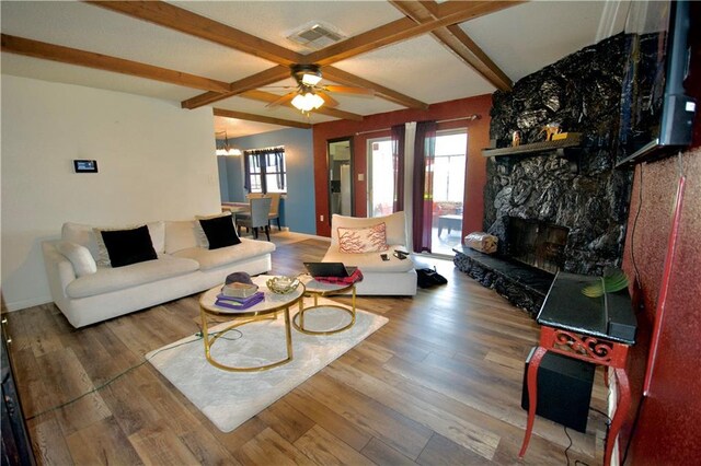 3209 Jennifer Ct, Marrero, LA 70072 - living room featuring ceiling fan, wood finished floors, a stone fireplace, and beamed ceiling