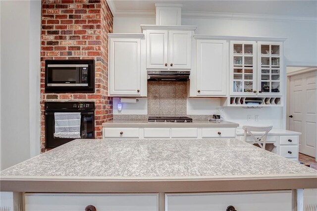 265 Remington Dr, Mandeville, LA 70448 - kitchen with built in microwave, stainless steel gas cooktop, light countertops, under cabinet range hood, and black oven