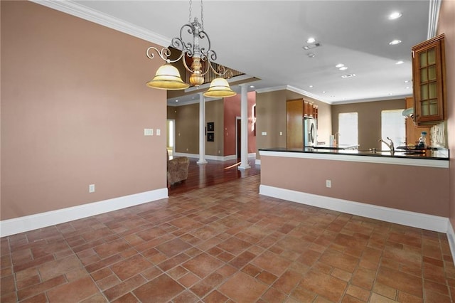 4540 Barataria Blvd, Marrero, LA 70072 - kitchen with dark countertops, baseboards, stainless steel fridge, crown molding, and brown cabinets