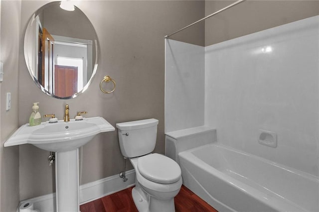4540 Barataria Blvd, Marrero, LA 70072 - full bathroom featuring wood finished floors, toilet, baseboards, and washtub / shower combination