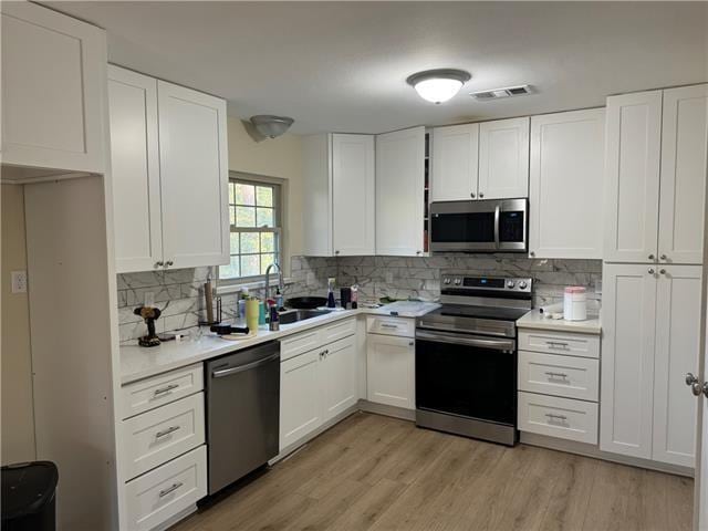 103 Marigold Dr, Covington, LA 70433 - kitchen with appliances with stainless steel finishes, a sink, light countertops, and white cabinetry
