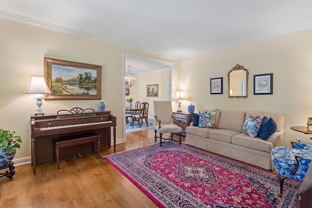 living area with crown molding, an inviting chandelier, wood finished floors, and baseboards