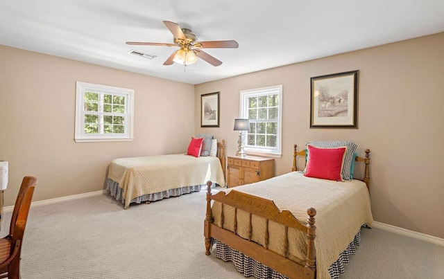 carpeted bedroom featuring visible vents, multiple windows, and baseboards