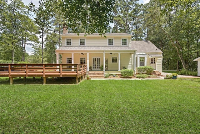 rear view of house featuring a chimney, ceiling fan, french doors, and a yard