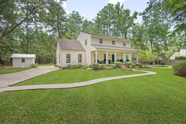 view of front of home featuring fence, a porch, a front lawn, and driveway