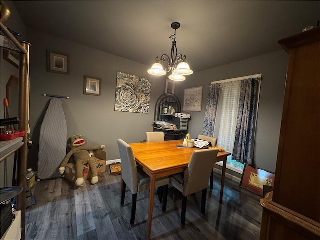 dining area with a chandelier, wood finished floors, and baseboards