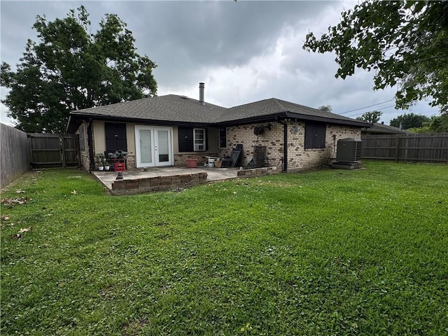 back of house featuring a lawn, a patio, a fenced backyard, and french doors