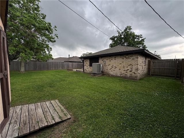 view of yard featuring a wooden deck, a fenced backyard, and cooling unit