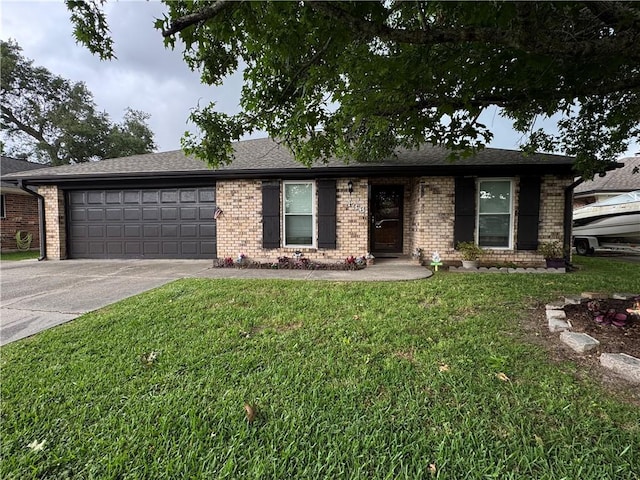 view of front facade with brick siding, a front yard, and an attached garage