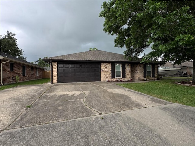 ranch-style house with driveway, a front lawn, brick siding, and an attached garage