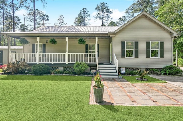 view of front of house featuring a porch, a front lawn, and metal roof