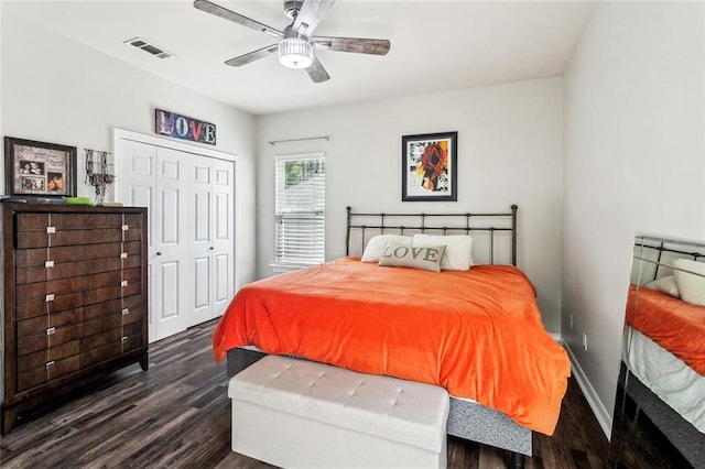 bedroom with dark wood finished floors, visible vents, a closet, baseboards, and ceiling fan