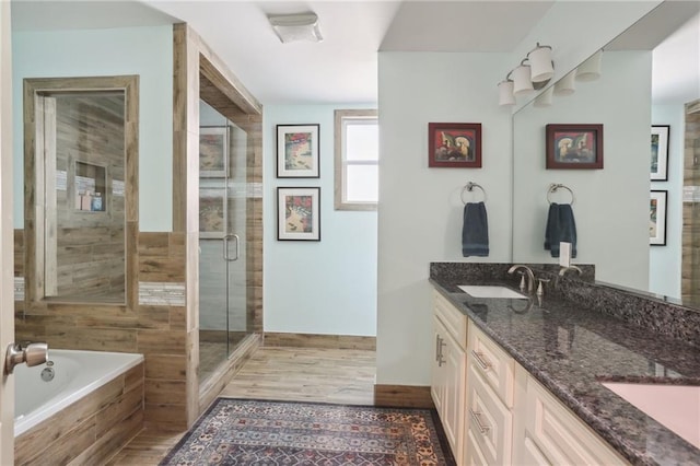 2634 Marengo St, New Orleans, LA 70115 - full bathroom featuring wood finished floors, a sink, a stall shower, a relaxing tiled tub, and double vanity