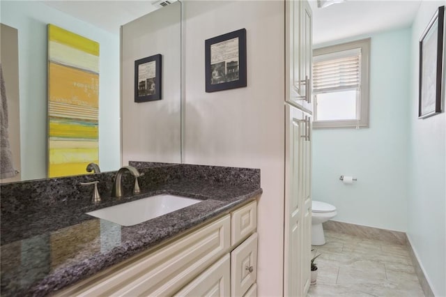 2634 Marengo St, New Orleans, LA 70115 - bathroom featuring vanity, marble finish floor, baseboards, and toilet