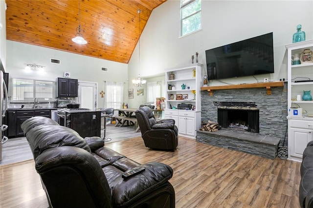 living room featuring wooden ceiling, light wood finished floors, high vaulted ceiling, and an inviting chandelier