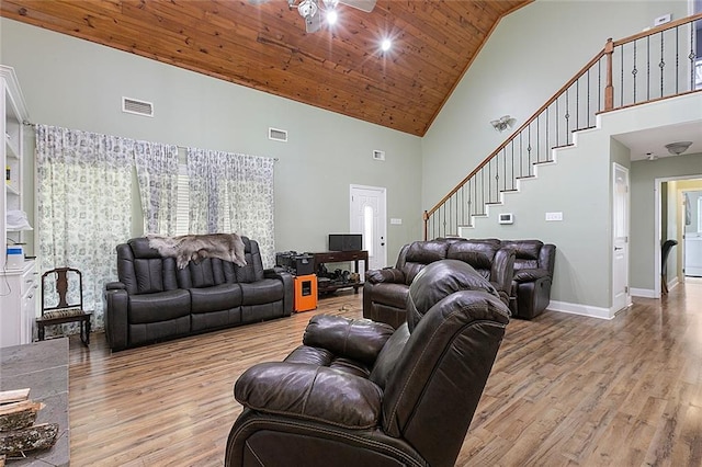 living room featuring high vaulted ceiling, light wood-style floors, and visible vents