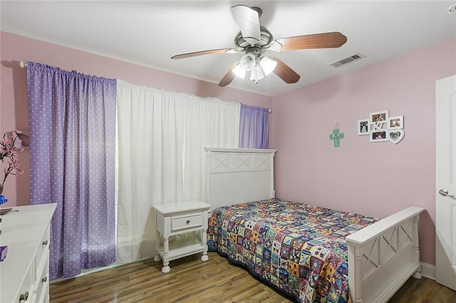 bedroom featuring a ceiling fan, wood finished floors, and visible vents