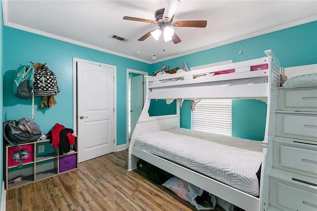 bedroom featuring wood finished floors, visible vents, ceiling fan, and crown molding