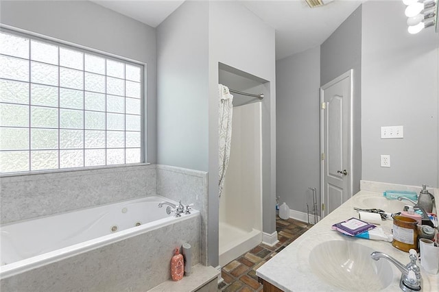 bathroom with a stall shower, a tub with jets, double vanity, and a healthy amount of sunlight