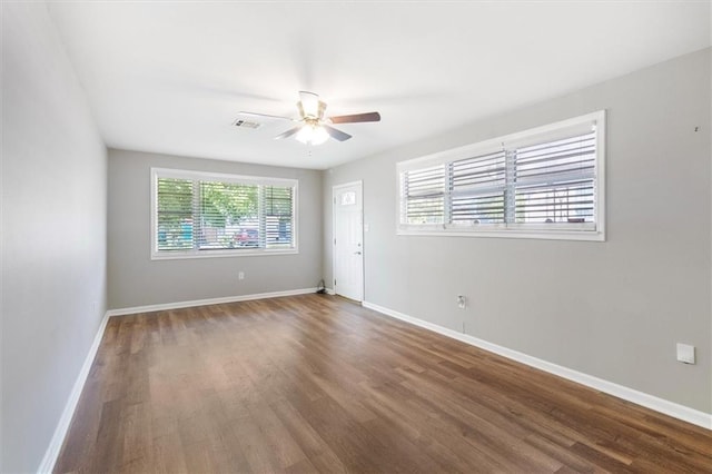 empty room with visible vents, baseboards, a ceiling fan, and wood finished floors