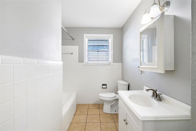 bathroom featuring tile patterned floors, vanity, tile walls, toilet, and bathing tub / shower combination