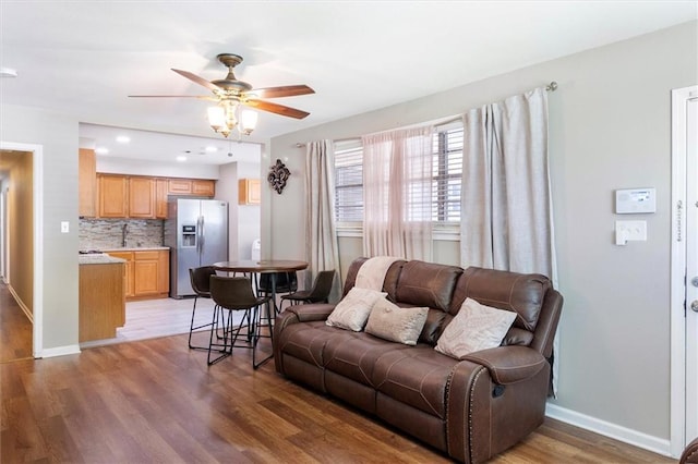 living area with ceiling fan, baseboards, light wood finished floors, and recessed lighting