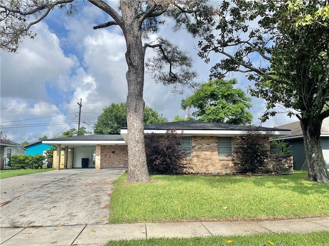 ranch-style home with driveway, a front yard, brick siding, and an attached carport