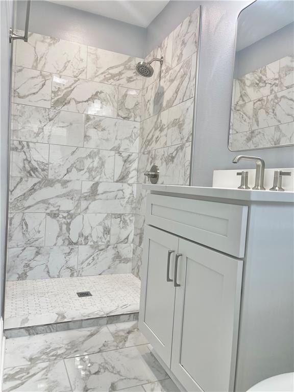 full bathroom with marble finish floor, a shower stall, and vanity