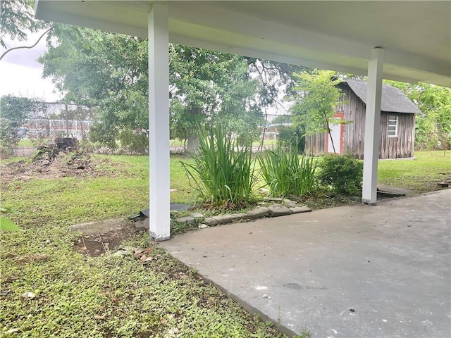 view of patio / terrace with fence and an outbuilding