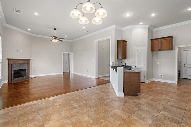 kitchen with ceiling fan with notable chandelier, open floor plan, ornamental molding, visible vents, and recessed lighting