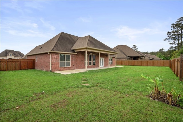 rear view of property featuring a ceiling fan, a fenced backyard, a yard, a patio, and brick siding