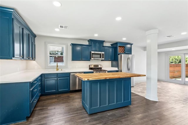 3824 Nashville Ave, New Orleans, LA 70125 - kitchen with a sink, stainless steel appliances, wood counters, blue cabinets, and visible vents