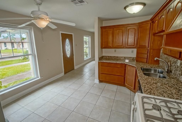 3760 W Louisiana State Dr, Kenner, LA 70065 - kitchen with visible vents, white range with gas stovetop, light tile patterned floors, a sink, and ceiling fan