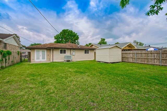 3760 W Louisiana State Dr, Kenner, LA 70065 - back of property featuring a storage shed, french doors, a lawn, and a fenced backyard