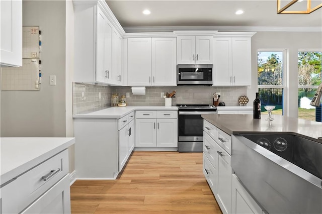 kitchen featuring light wood-style floors, tasteful backsplash, appliances with stainless steel finishes, and white cabinetry