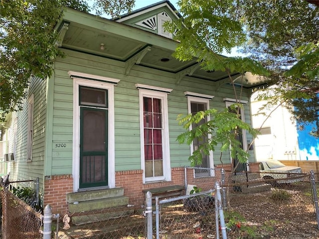 520002 Magazine St, New Orleans, LA 70115 - view of front facade featuring entry steps, a gate, a fenced front yard, and brick siding