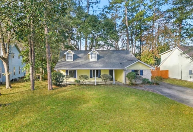 cape cod house featuring a front lawn, aphalt driveway, and fence