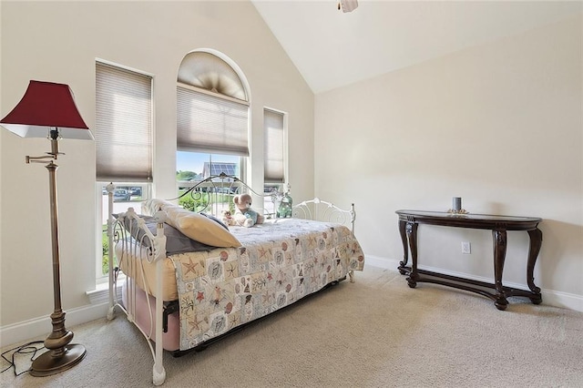 carpeted bedroom featuring high vaulted ceiling and baseboards