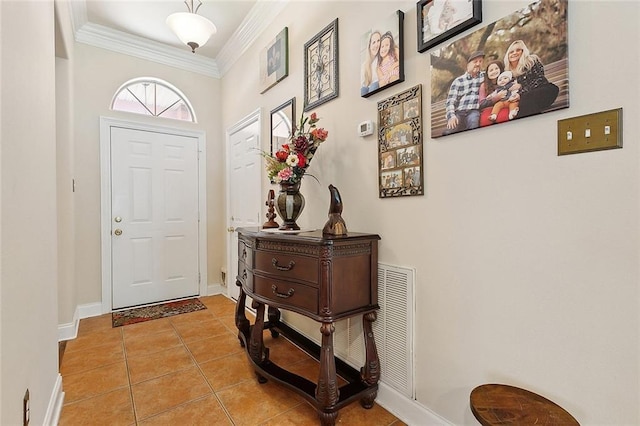 foyer featuring light tile patterned flooring, visible vents, crown molding, and baseboards