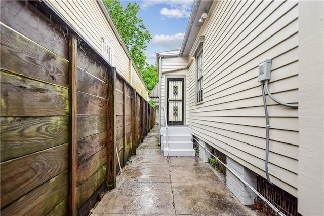 view of side of property with fence and entry steps