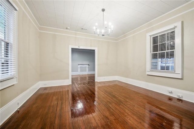 unfurnished dining area featuring visible vents, crown molding, baseboards, hardwood / wood-style flooring, and a notable chandelier