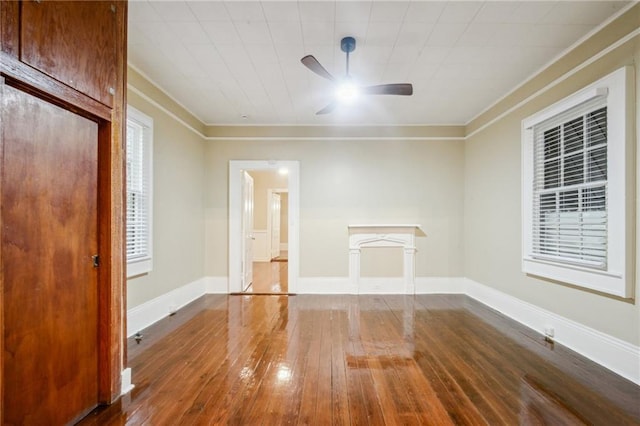 unfurnished living room featuring ceiling fan, baseboards, ornamental molding, and hardwood / wood-style floors