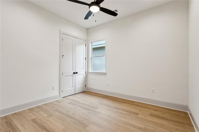 unfurnished bedroom with light wood finished floors, baseboards, a closet, and ceiling fan