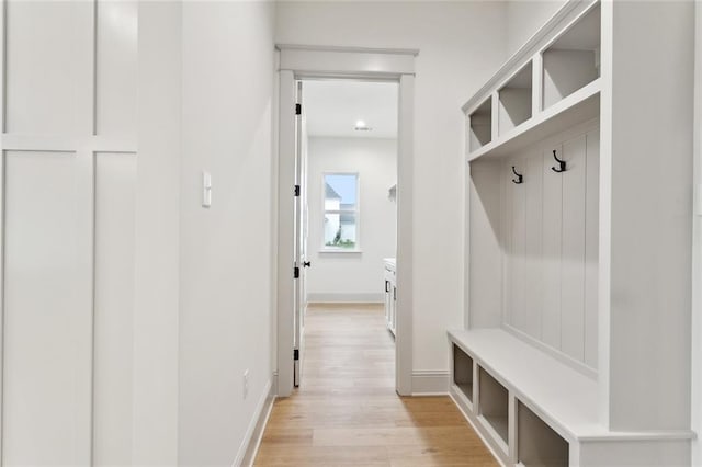 mudroom with light wood finished floors and baseboards