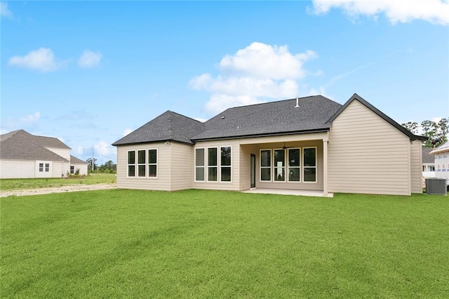rear view of house with a patio area, roof with shingles, a yard, and central air condition unit