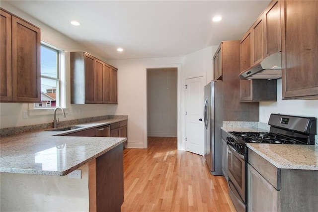 2900 General Taylor St, New Orleans, LA 70115 - kitchen with light wood-type flooring, a sink, a peninsula, under cabinet range hood, and stainless steel appliances
